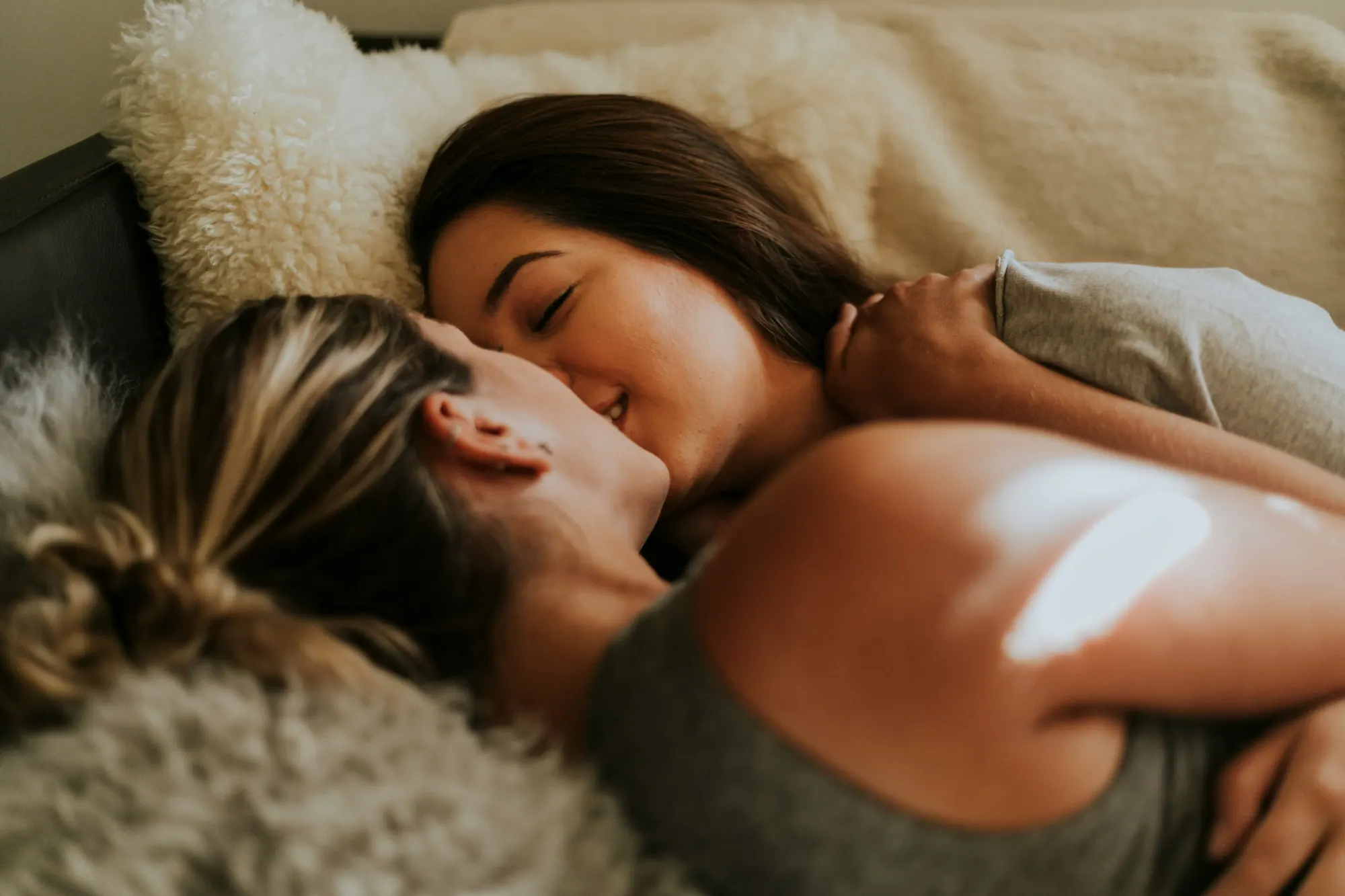 Zwei Frauen liegen eng umschlungen im Bett