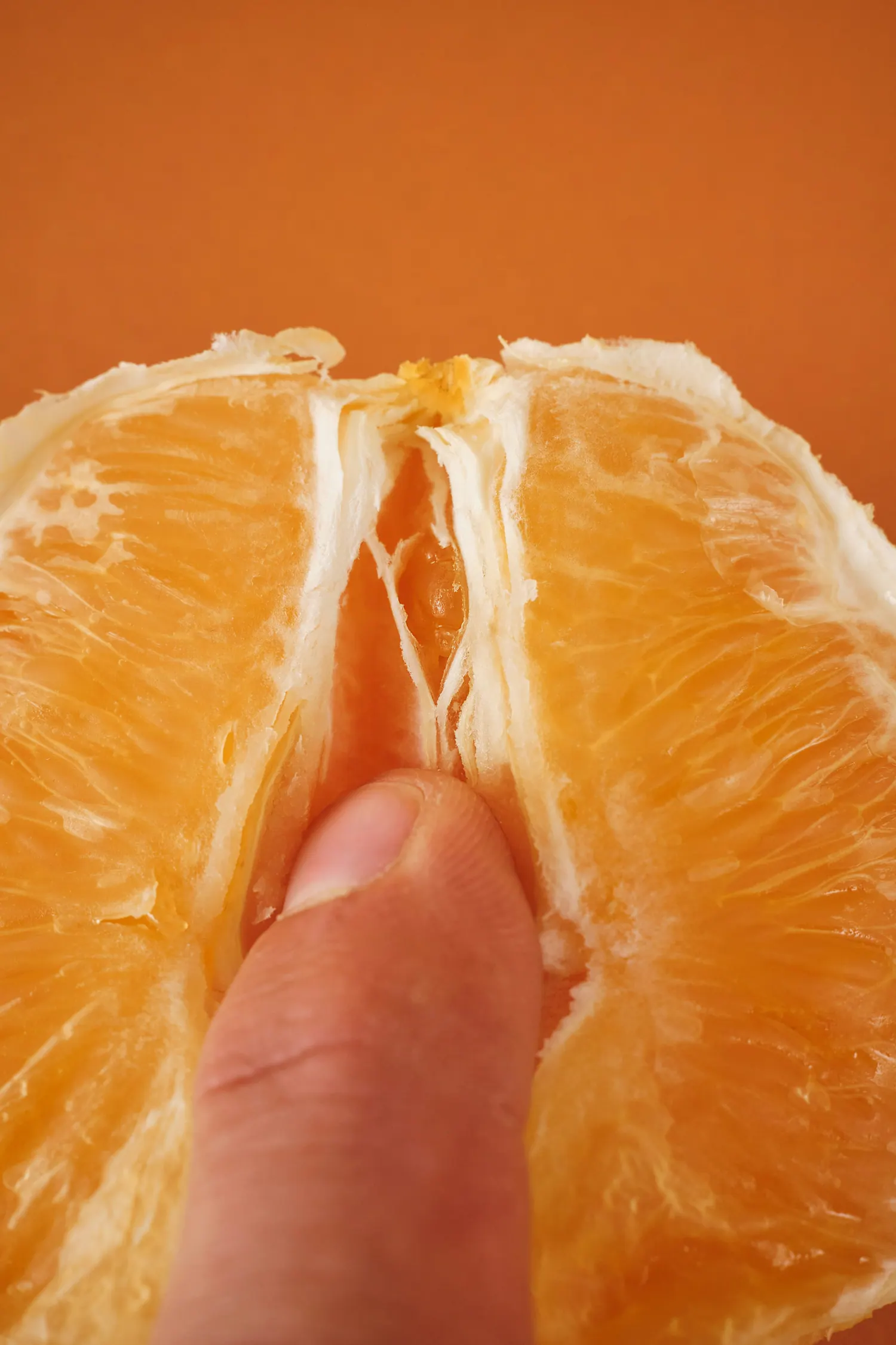 Ein Finger in einer aufgeschnittenen Orange